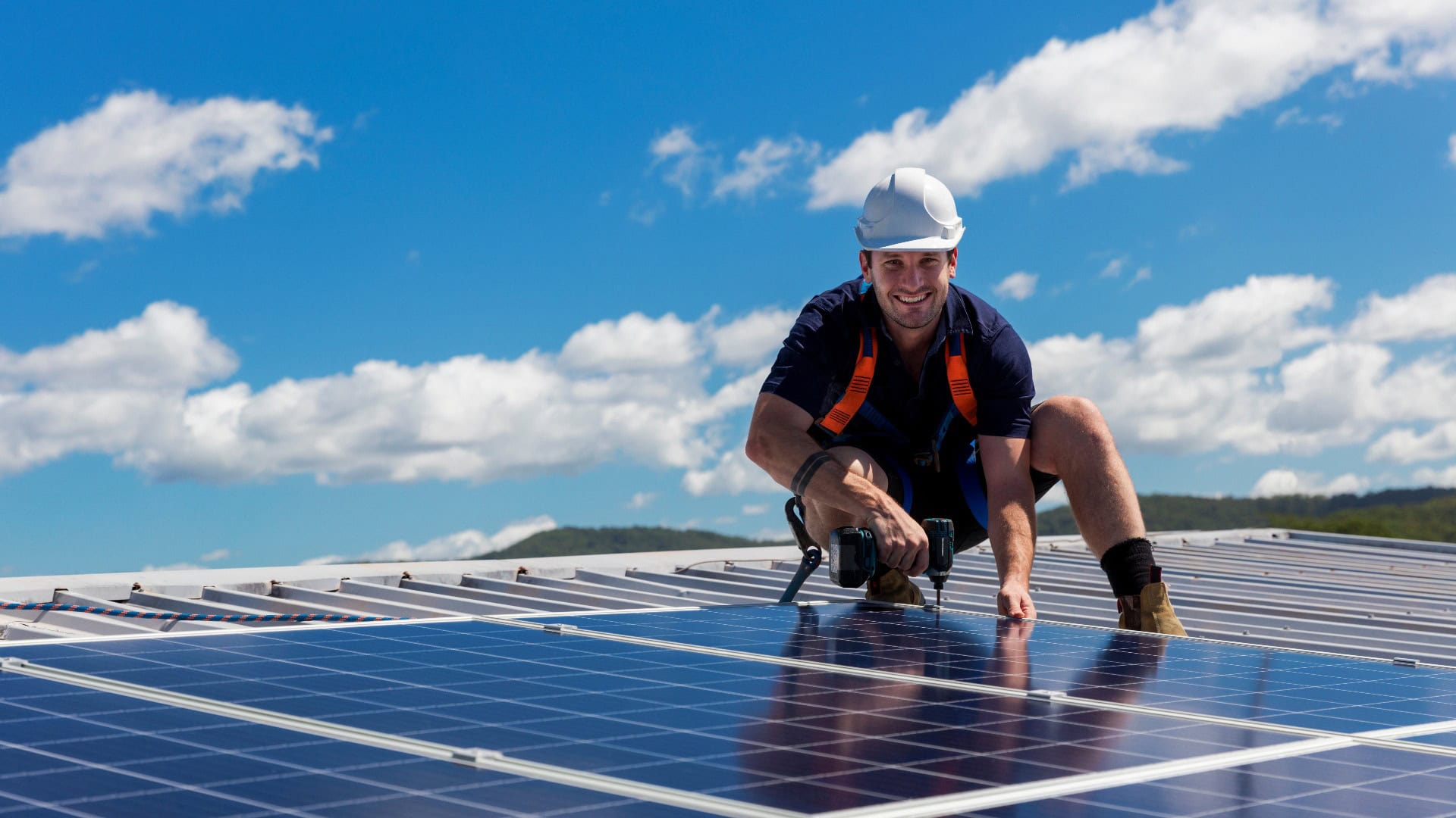 Solarmodultechniker mit Bohrmaschine bei der Installation von Solarmodulen